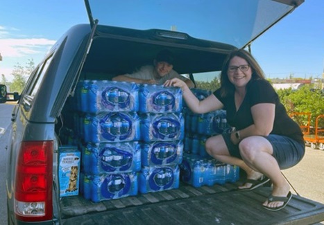 Tracy Ferguson and her son Caleb, load water bottles into the car for donations